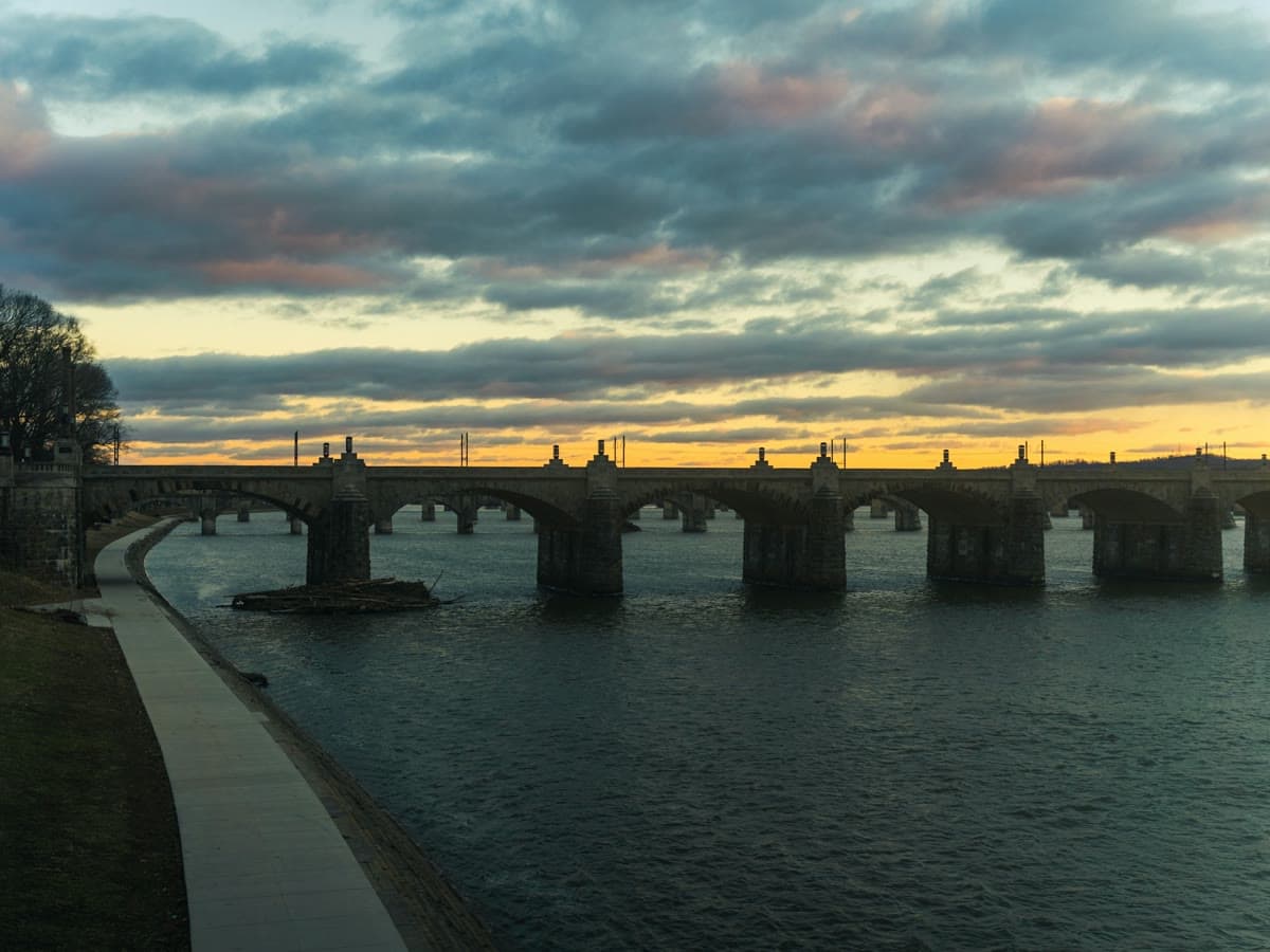 A stone arch bridge over the Susquehanna River in Harrisburg at sunset