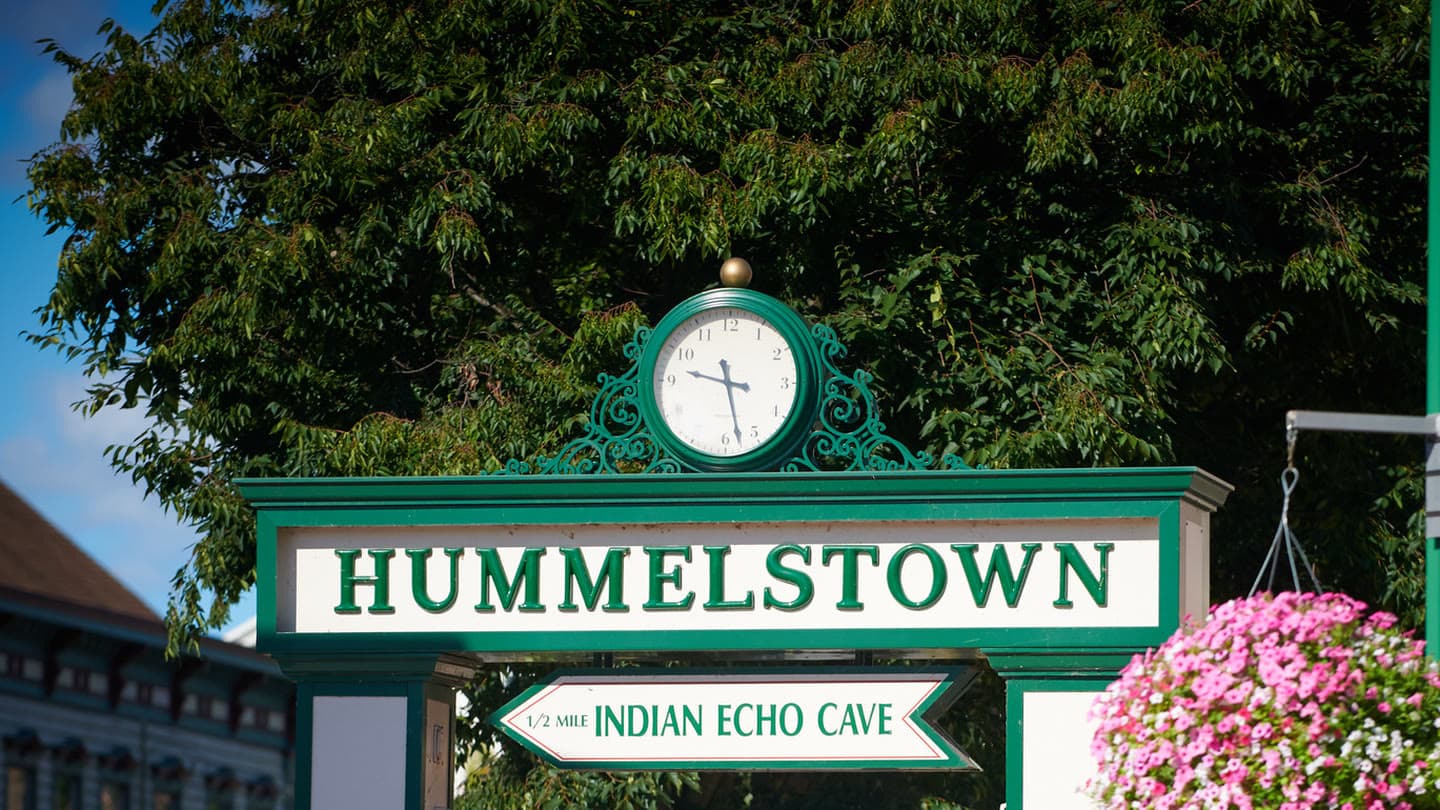 The green Hummelstown arch on Main Street, with the town clock above it and a sign to Indian Echo Caverns